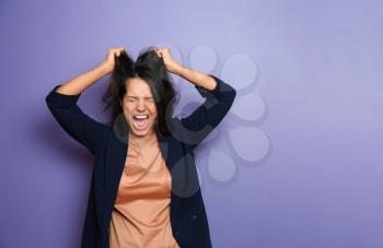 Screaming young woman on color background�