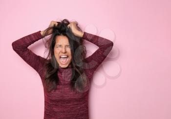 Screaming young woman on color background�