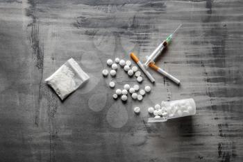 Syringe with drugs on grey background. Concept of addiction�