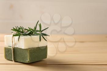 Soap bars with rosemary on wooden table�