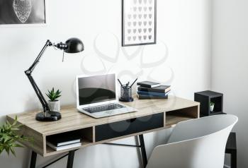 Stylish workplace with laptop in room�