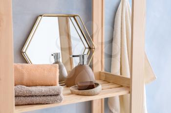 Towels and soap on shelf in bathroom�