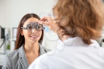 Ophthalmologist examining young woman in clinic�