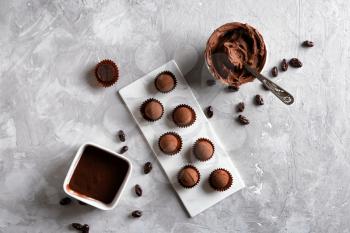 Tasty sweet truffles with cacao powder and ganache on grey table�