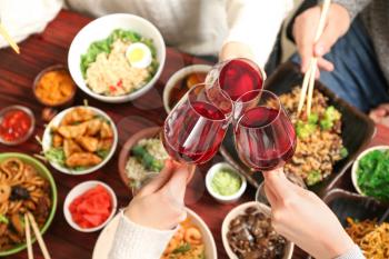 Friends with glasses of wine in Chinese restaurant, closeup�
