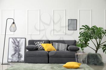 Stylish interior of living room with comfortable grey sofa�