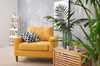 Green tropical leaves in interior of living room�