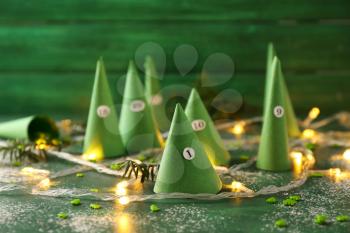 Paper cones with numbers and sweets on color background. Christmas celebration�