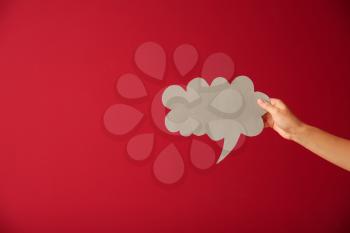 Female hand with blank speech bubble on color background�