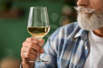 Senior man drinking wine at home, closeup�