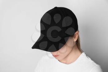 Woman wearing blank cap on light background�