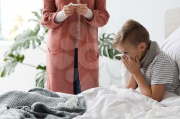 Mother taking care of his son ill with flu at home�