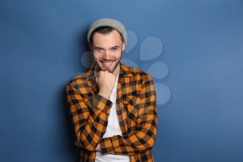 Fashionable young man in checkered shirt on color background�