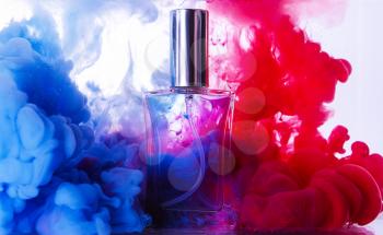 Bottle of perfume in color smoke�