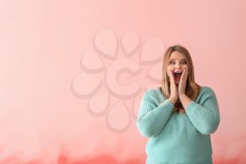 Surprised plus size girl on color background. Concept of body positivity�