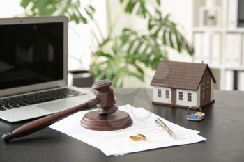 Rings with decree of divorce, judge gavel and house model on table. Concept of dividing marital property�