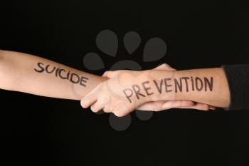 Female hands with text SUICIDE PREVENTION on dark background�