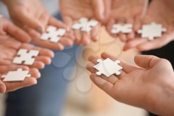 People holding pieces of jigsaw puzzle, closeup�