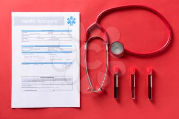 Medical insurance form with stethoscope and blood samples on color background. Health care concept�