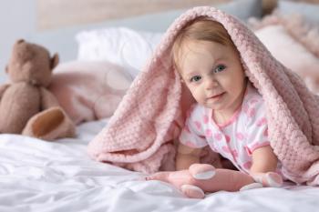 Portrait of cute little baby on bed at home�