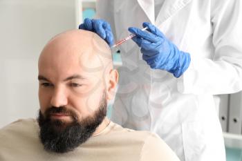 Man with hair loss problem receiving injection in clinic�