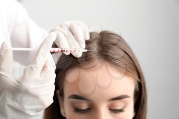 Woman with hair loss problem receiving injection in clinic�