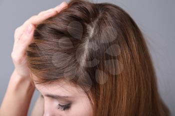 Woman with hair loss problem on grey background, closeup�