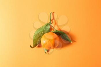 Tasty juicy tangerine on color background�