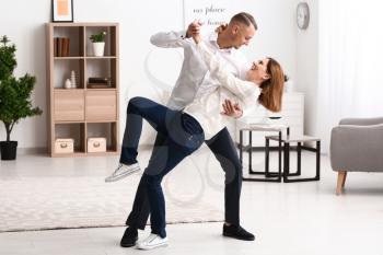 Beautiful couple dancing at home�