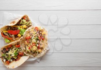 Tasty tacos on white wooden table�