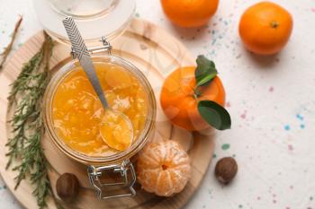 Jar of tasty tangerine jam on light table�