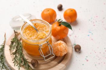 Jar of tasty tangerine jam on light table�