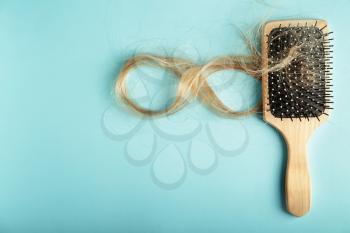 Brush with fallen down hair on color background�