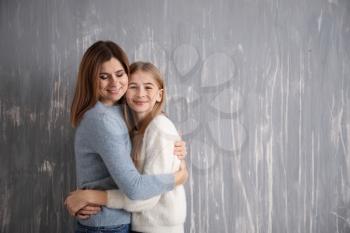 Portrait of happy mother and daughter on grey background�