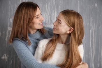 Portrait of happy mother and daughter on grey background�