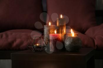 Beautiful burning candles on table in room�