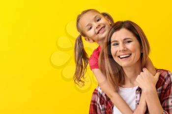 Portrait of happy mother with daughter on color background�