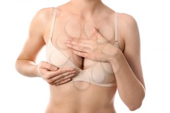 Young woman checking her breast on white background. Cancer awareness concept�