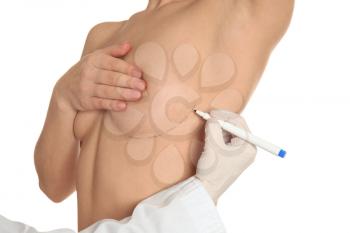 Doctor drawing marks on female breast before cosmetic surgery operation against white background�