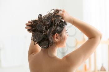 Young woman washing her beautiful hair in bathroom�