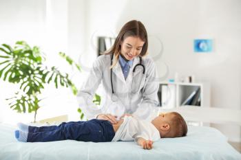 Female doctor working with cute little boy in clinic�