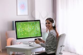 Beautiful young woman playing computer game at home�