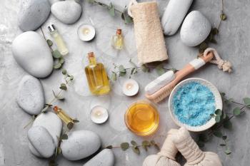 Spa composition with stones and cosmetics on grey background 