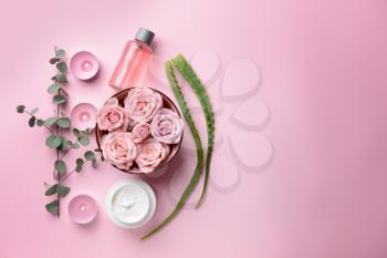 Spa composition with flowers, candles and essential oil on color background�
