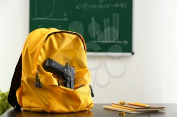 Backpack with pistol on table in classroom. No guns in school�