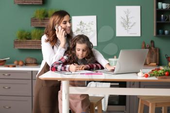 Busy mother with daughter working at home�