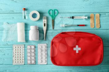 First aid kit on color wooden background�
