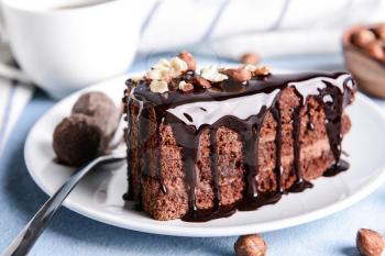Plate with piece of tasty chocolate cake on table�
