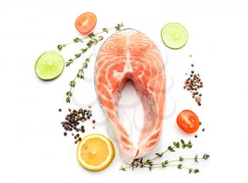 Piece of fresh salmon with spices on white background�