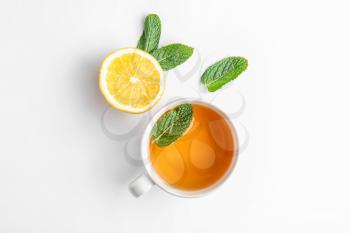 Cup of hot tea, mint and lemon on white background�